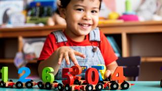 child smiling with number toys