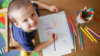 child smiling and drawing