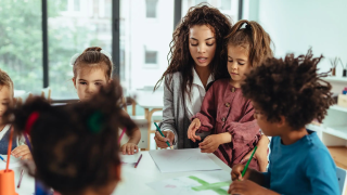 Preschool teacher playing with children.