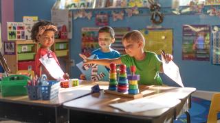 Three Children working at table in a classroom