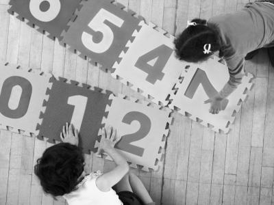 kids playing on a playmat of numbers and letters