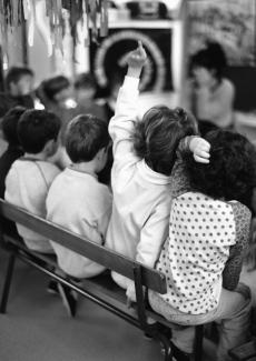 child raising hand in class