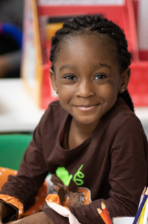 child smiling in a classroom setting